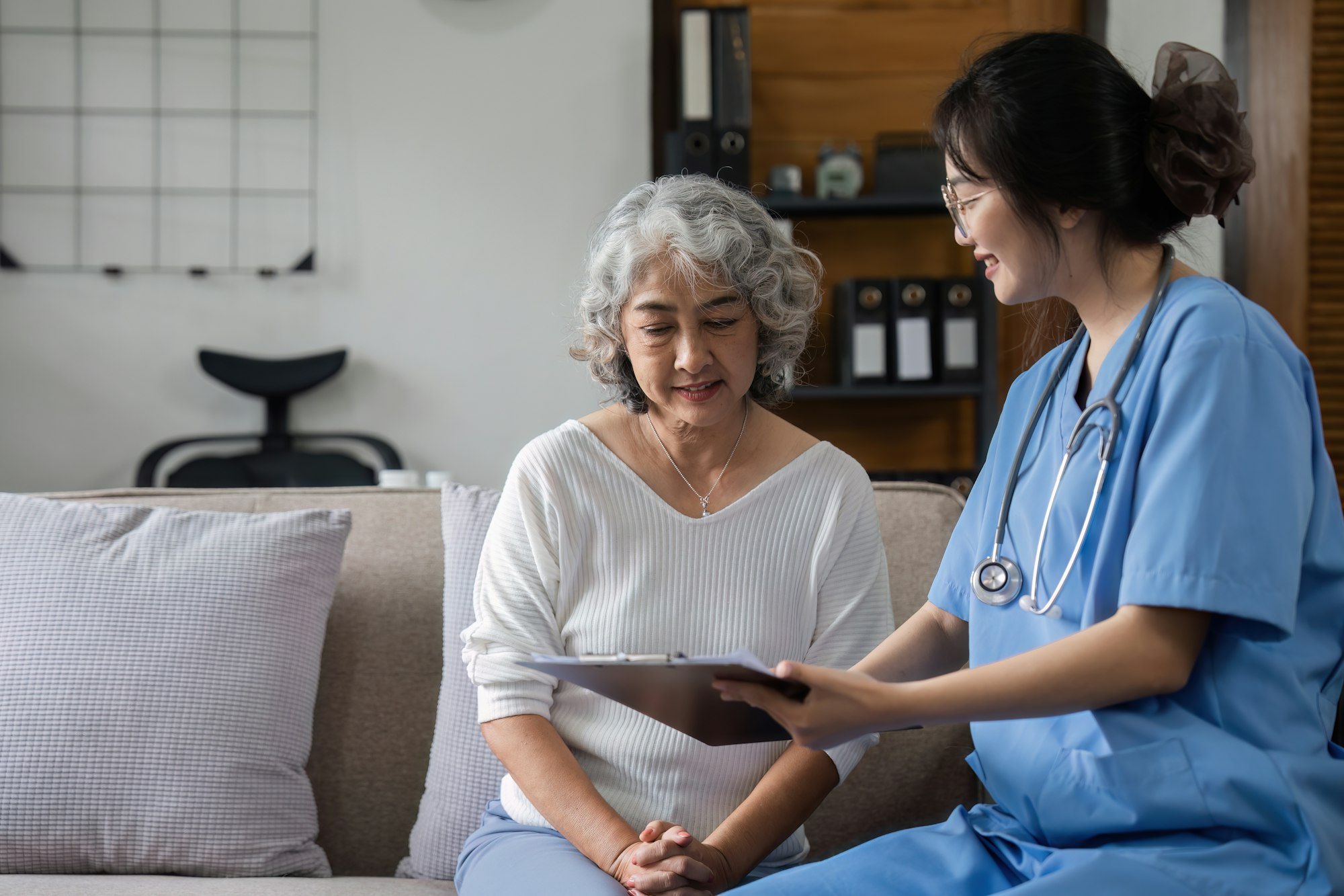 Elderly caregivers are helping to check the health and care for an elderly woman at home.